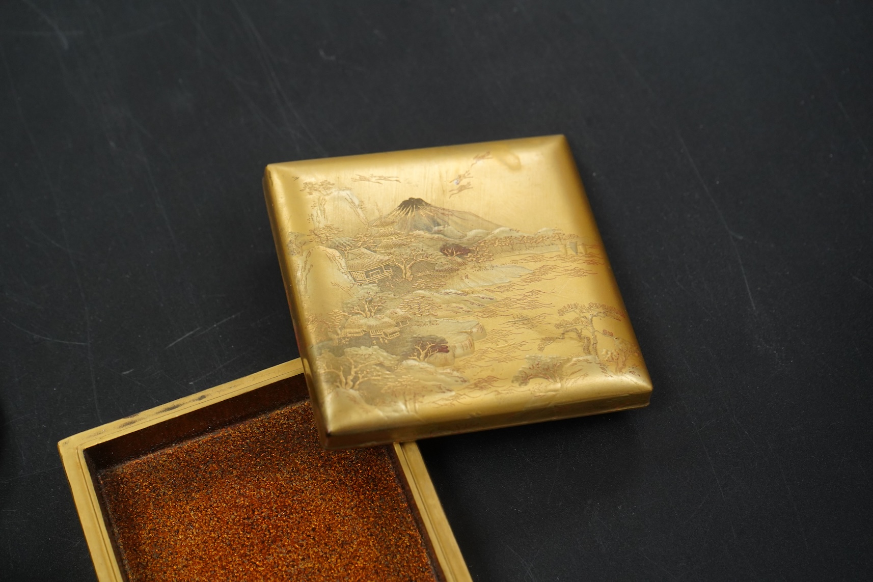 Three Japanese gilt lacquer boxes, one depicting Mount Fuji, largest 9cm wide